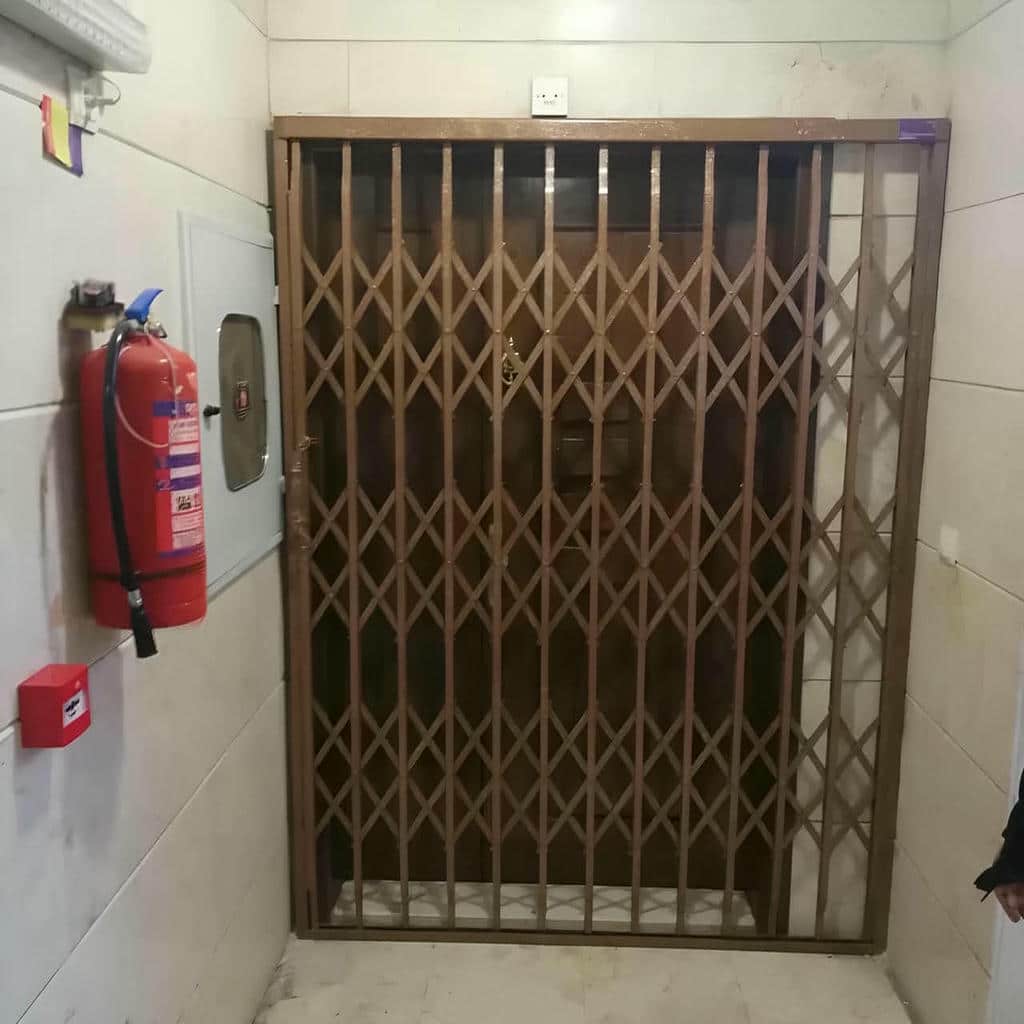 حفاظ درب آکاردئونی جمع شده کنار ورودی