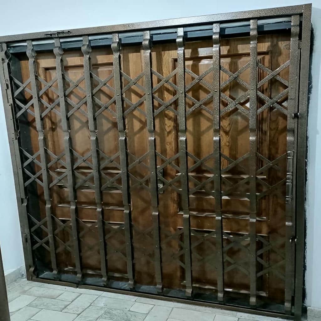 محافظ جمع شونده فلزی کنار درب چوبی